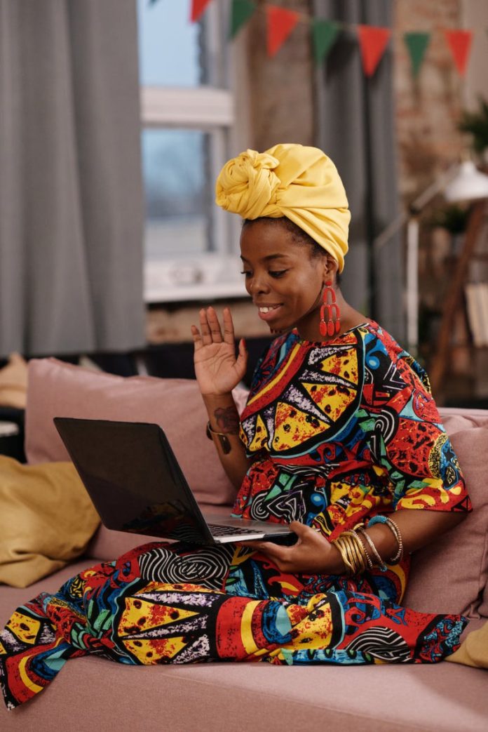 photo of woman waving on her laptop
