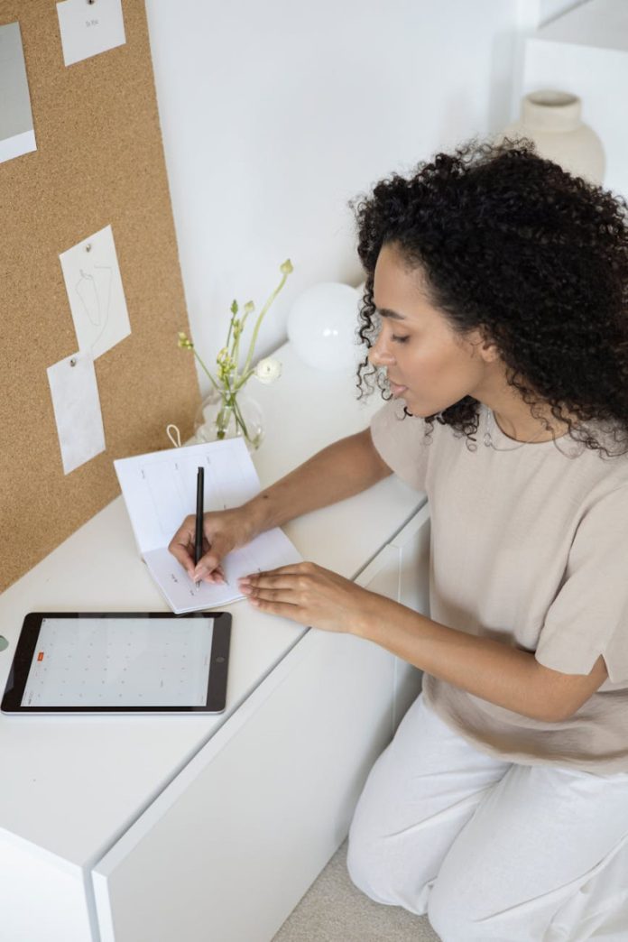 a woman with curly hair writing