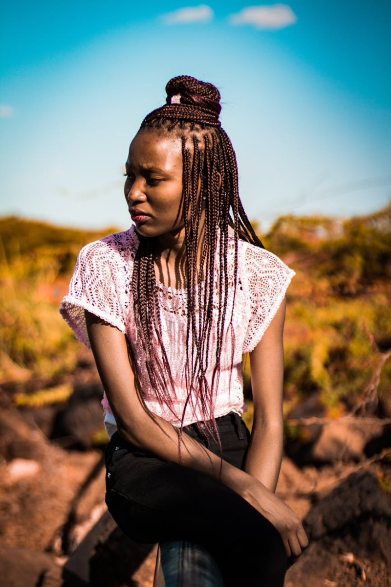 black woman wearing white lace shirt and black bottos