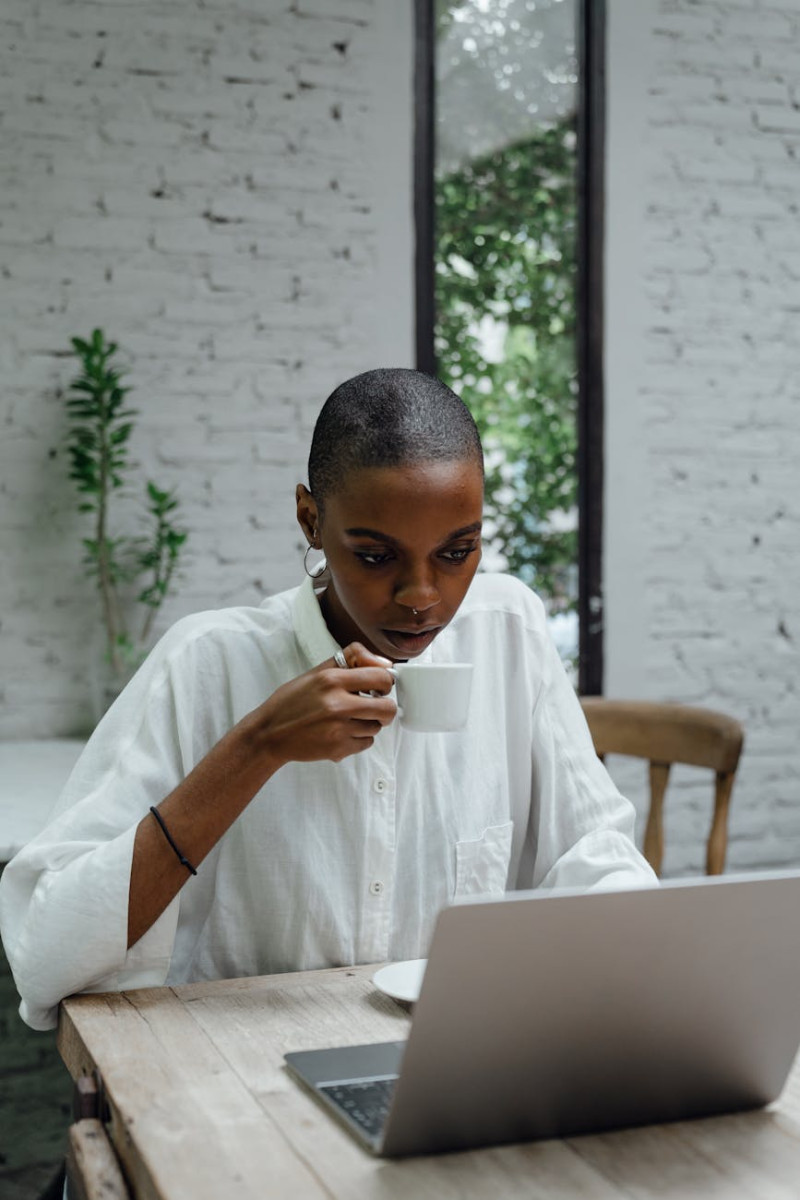 serious black businesswoman using laptop while sitting in cafe finance and budgeting
