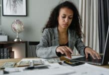 How Unconsciously Spending Destroys Your Financial Dreams (And How to Stop It) a woman in plaid blazer using her laptop and mobile phone