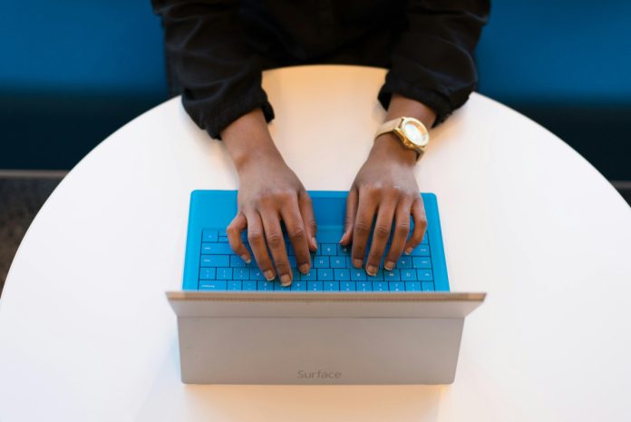 black hands typing on computer